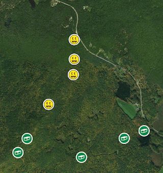 Satellite view of wooded area superimposed with symbols denoting found and unfound geocache locations.